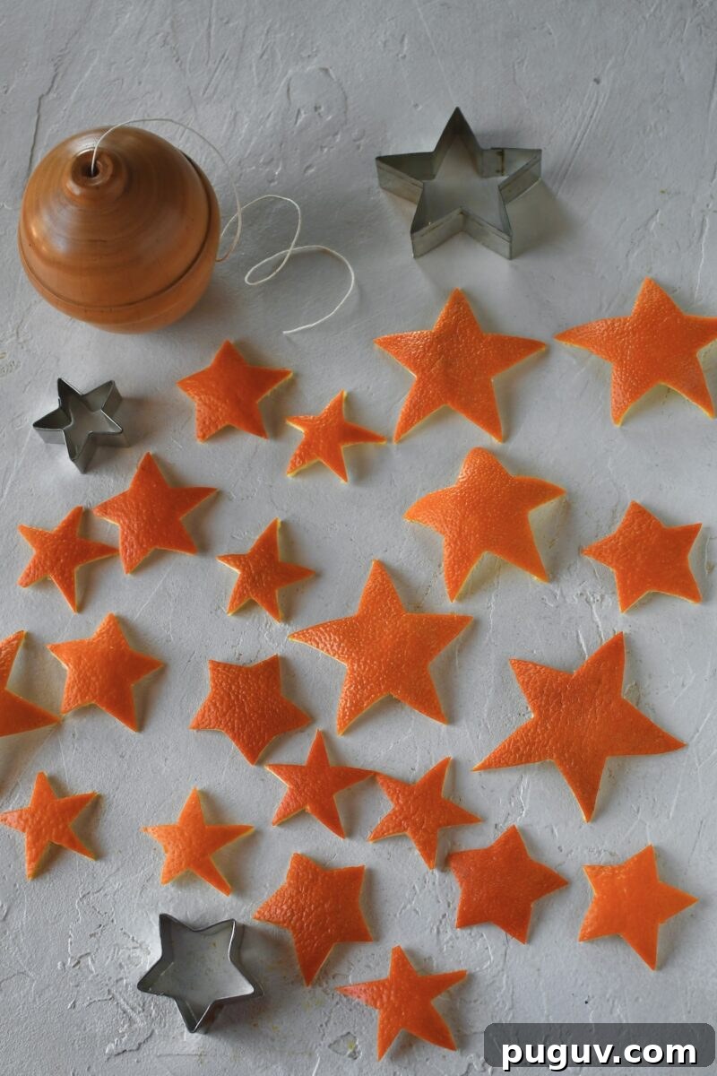 DIY Orange Peel Star Garland: Natural Holiday Decoration Tutorial 10 Cut out orange peel stars laid out on a table, in various sizes.