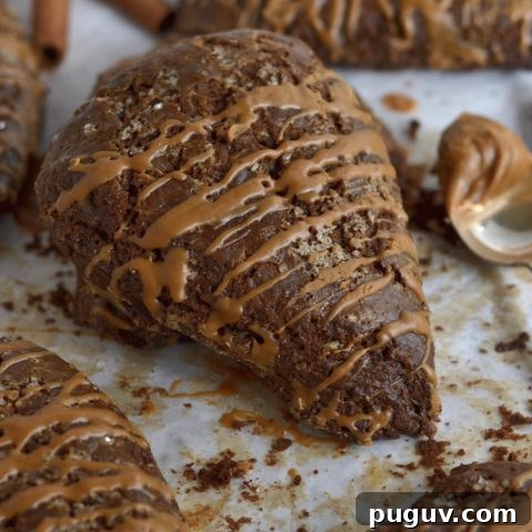 Gingerbread scones on parchment paper with a spoonful of Biscoff spread on the side