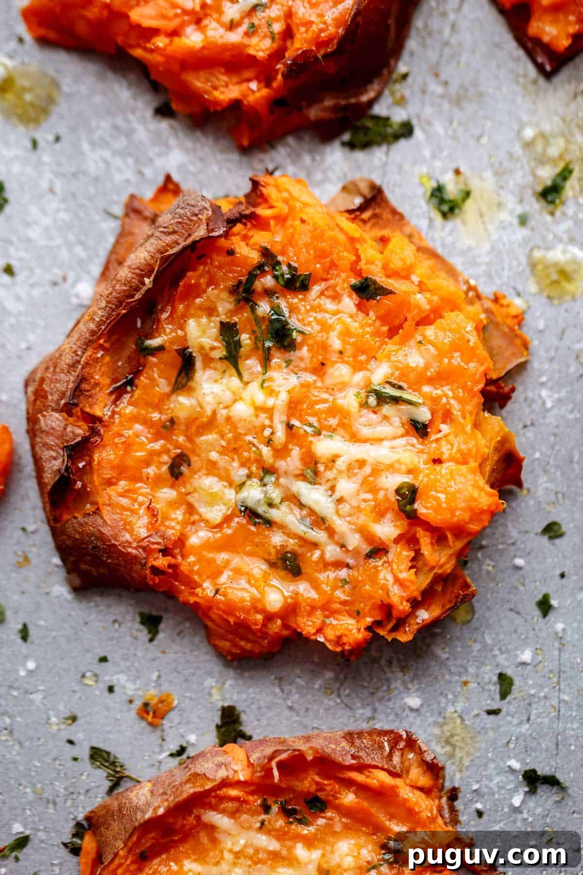 Garlic Butter Smashed Sweet Potatoes with Parmesan Crisps 10 Top view Image of a single slice of grilled, smashed sweet potato with parmesan and parsley.