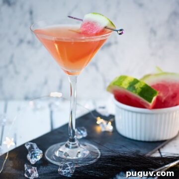 Refreshing Watermelon Martini Recipe: How to Mix the Perfect Cocktail 13 Gorgeous watermelon martini with a watermelon garnish, placed on a black slate plate.