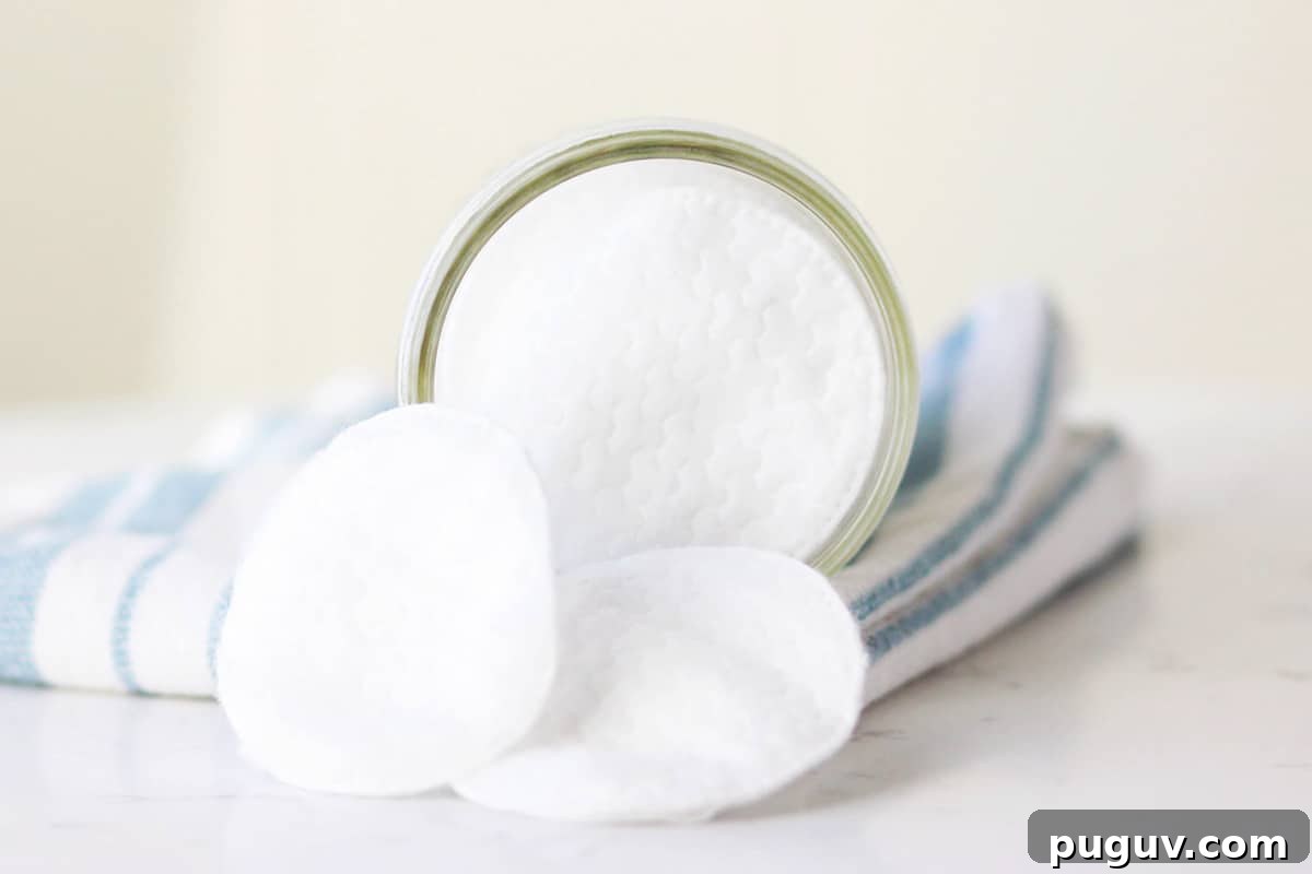 Make Your Own Coconut Oil Makeup Remover Wipes at Home 3 a mason jar with cotton rounds in it and a striped washcloth laying under it