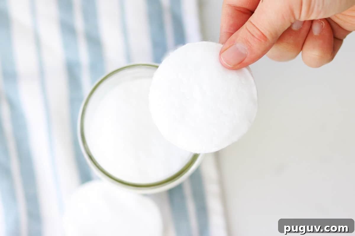 Make Your Own Coconut Oil Makeup Remover Wipes at Home 6 a mason jar with cotton rounds in it and a striped washcloth laying under it