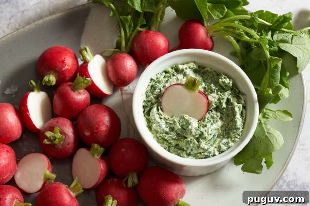 Radishes on a gray plate with a crock of radish leaf butter.