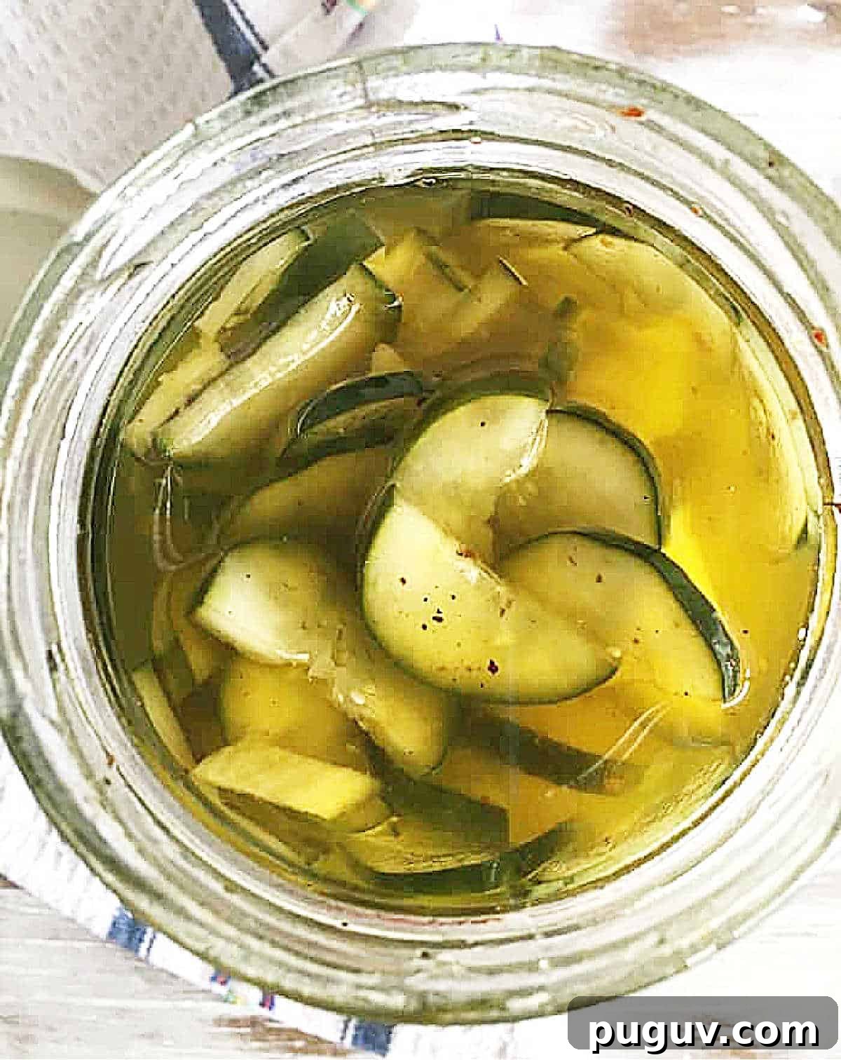 Quick Refrigerator Pickled Cucumbers: Tangy Crunch in 24 Hours 3 Top view of jar with pickled cucumbers in olive oil.