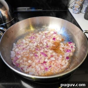 Classic Oven-Baked Beans Recipe with Step-by-Step Video 8 Diced onions cooking in a pan.