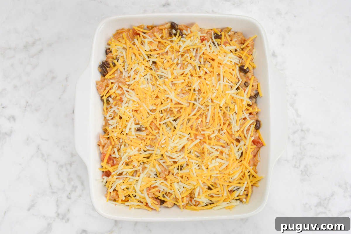 Doritos Casserole Recipe with WW SmartPoints and Tips 11 A white square baking dish filled with the casserole mixture and topped entirely with orange and white shredded cheese.