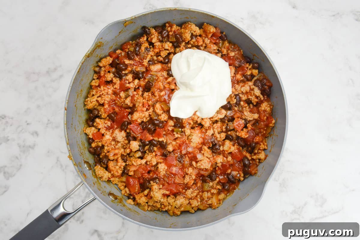 Doritos Casserole Recipe with WW SmartPoints and Tips 7 A skillet with casserole filling and a scoop of Greek yogurt