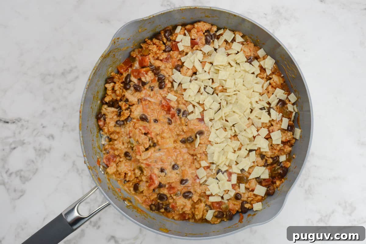 Doritos Casserole Recipe with WW SmartPoints and Tips 8 Small white pieces of corn tortilla sit on top of the mixed ingredients