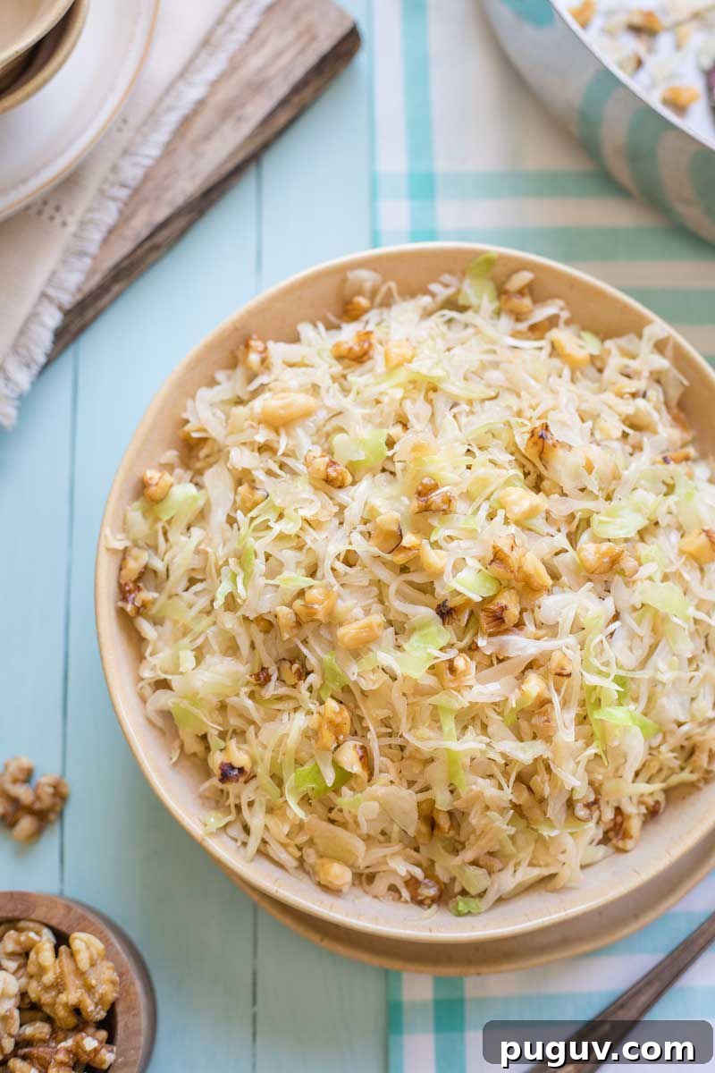 Brown Butter Sautéed Cabbage with Toasted Walnuts 9 Overhead of finished recipe in serving bowl, with empty saute pan, extra nuts, and serving pieces at photo corners.