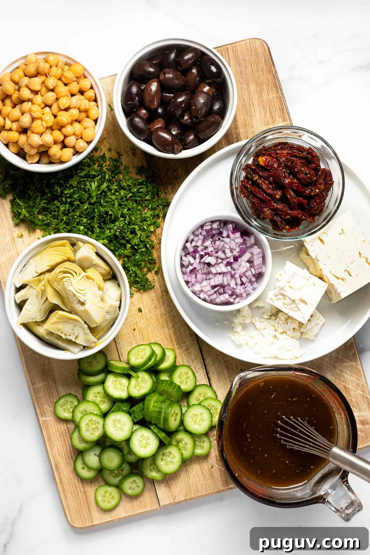 20-Minute Greek Orzo Salad with Feta & Olives 3 Wooden cutting board with ingredients to make Greek orzo salad on it