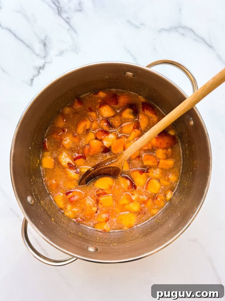 Macerated peaches to make jam in a big pot.