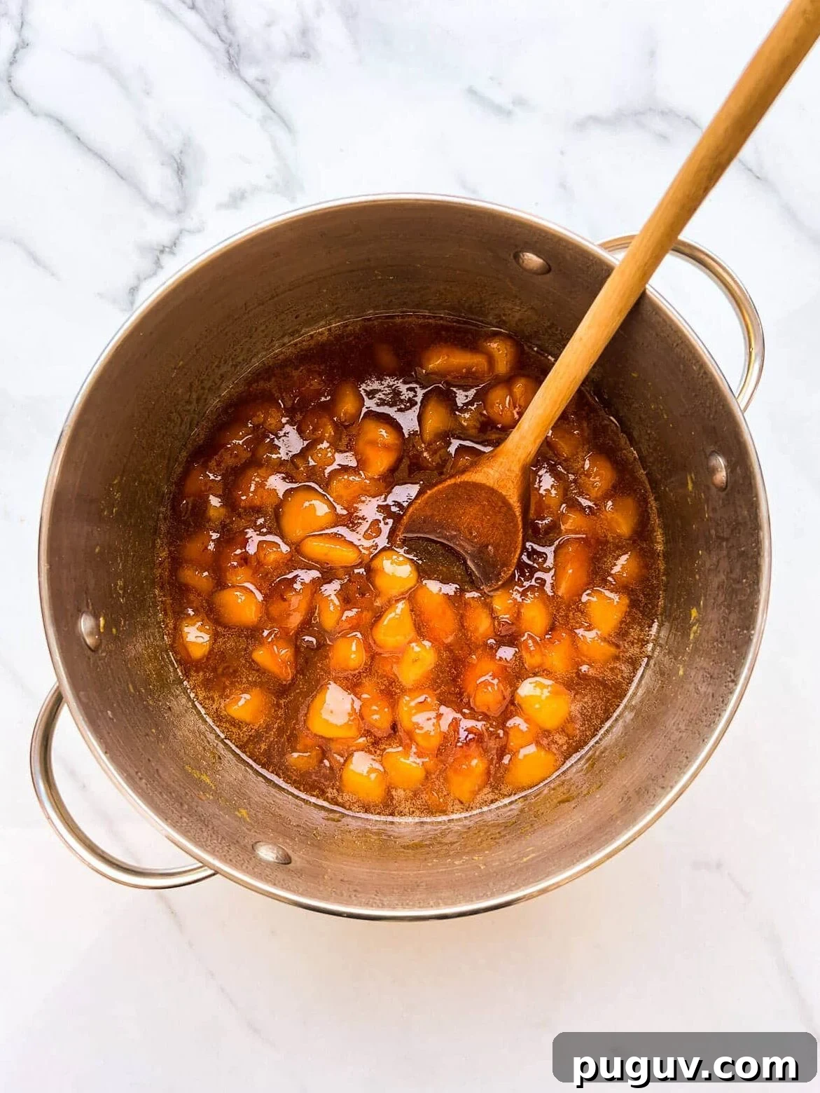 A pot of peach jam after boiling to the jam setting point on the stove.