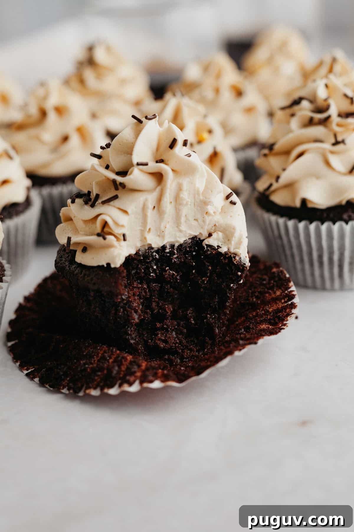 A mocha cupcake with a bite taken out of it