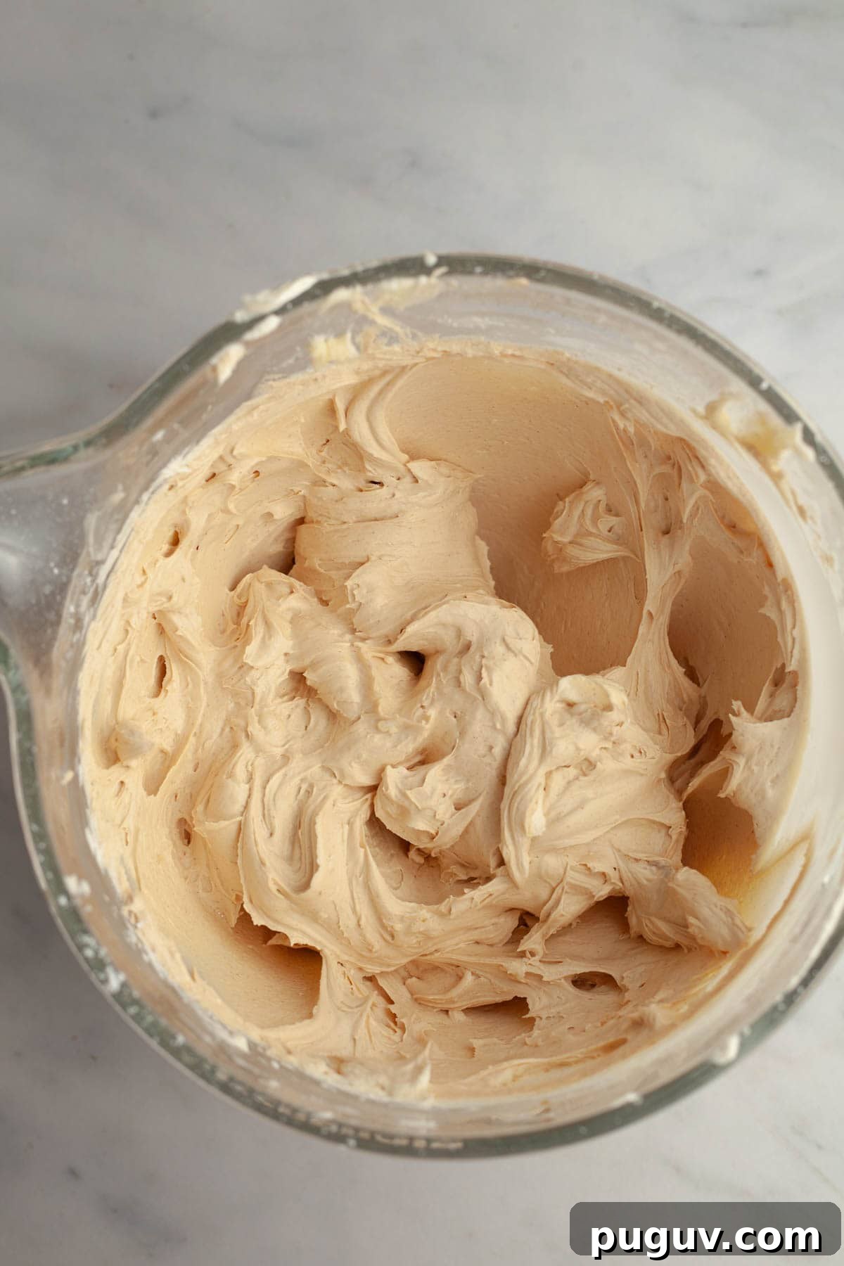 Coffee buttercream in a large glass bowl.