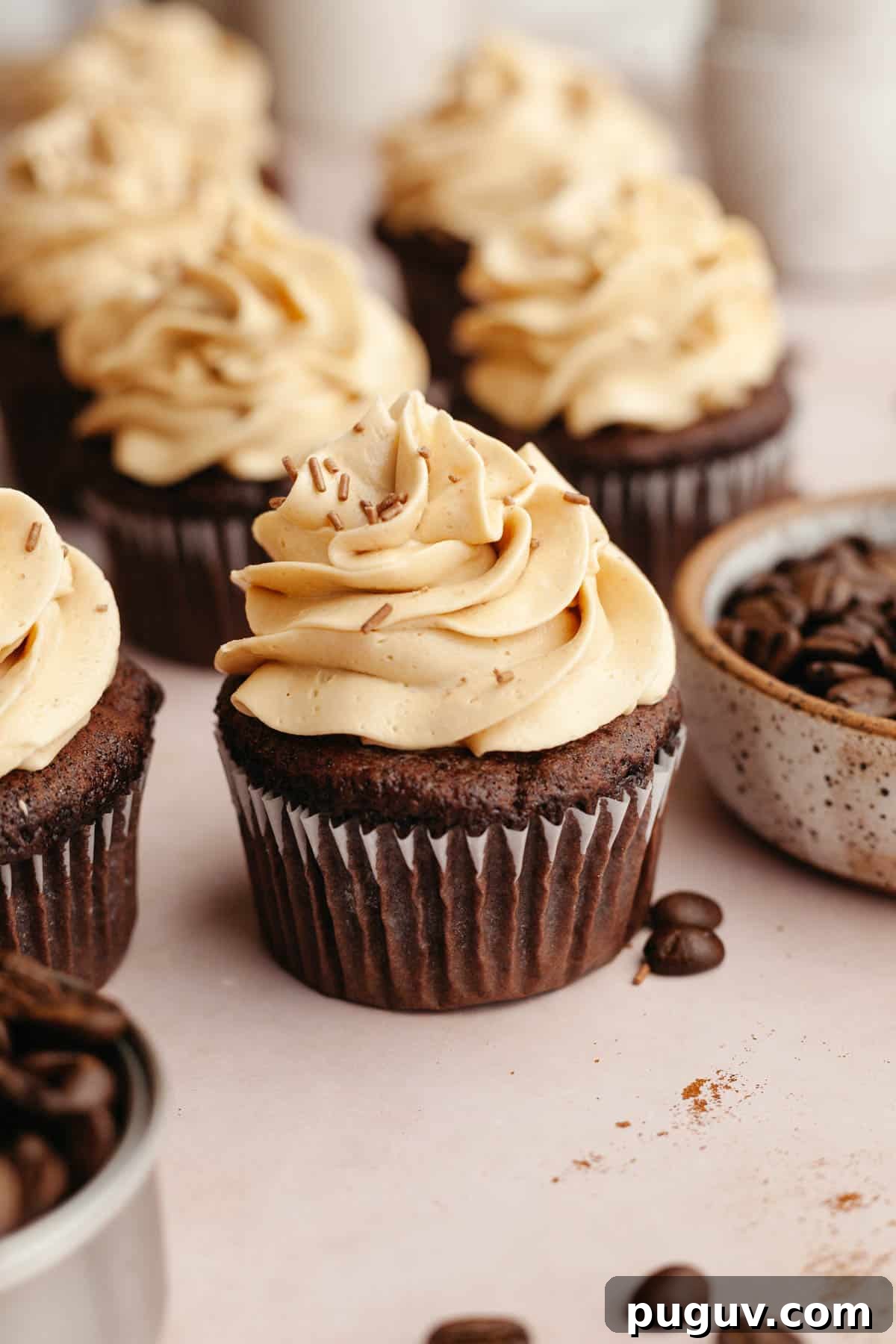 Chocolate cupcakes covered in a light brown frosting.
