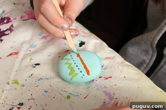 Kid painting rock to look like Easter Egg