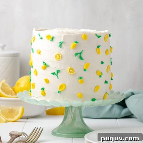 A decorated gluten free lemon cake sitting on a green cake stand.