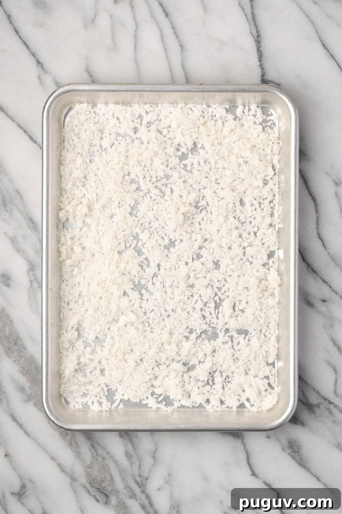 Decadent Chocolate Coconut Cake Recipe (Moist & Easy to Make) 8 Sweetened coconut flakes spread on a small baking sheet.