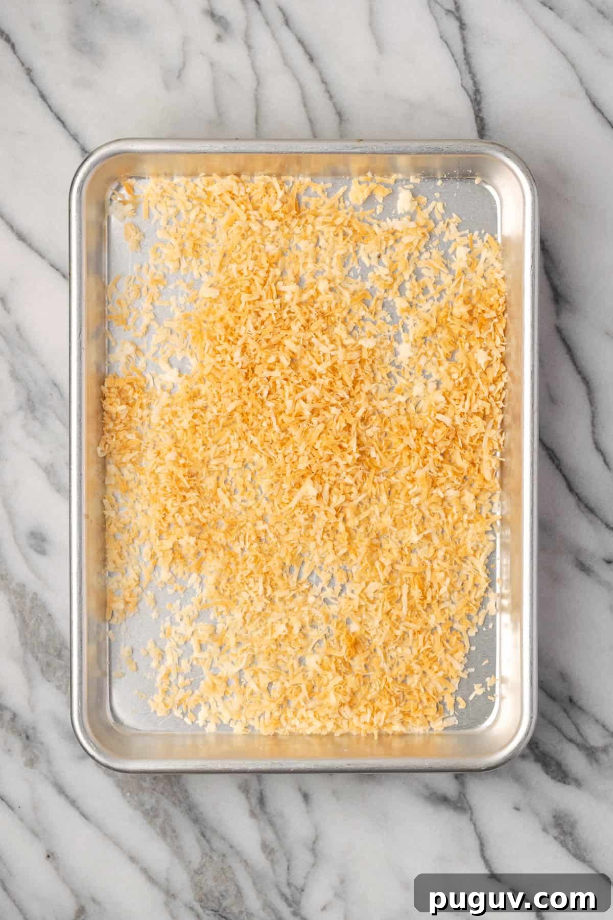 Decadent Chocolate Coconut Cake Recipe (Moist & Easy to Make) 9 Golden brown shredded coconut on a small baking sheet.