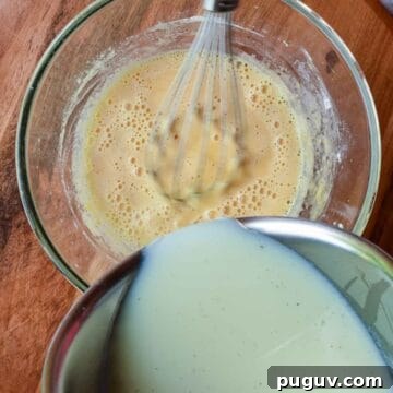 Milk being poured into a bowl of yellow liquid.