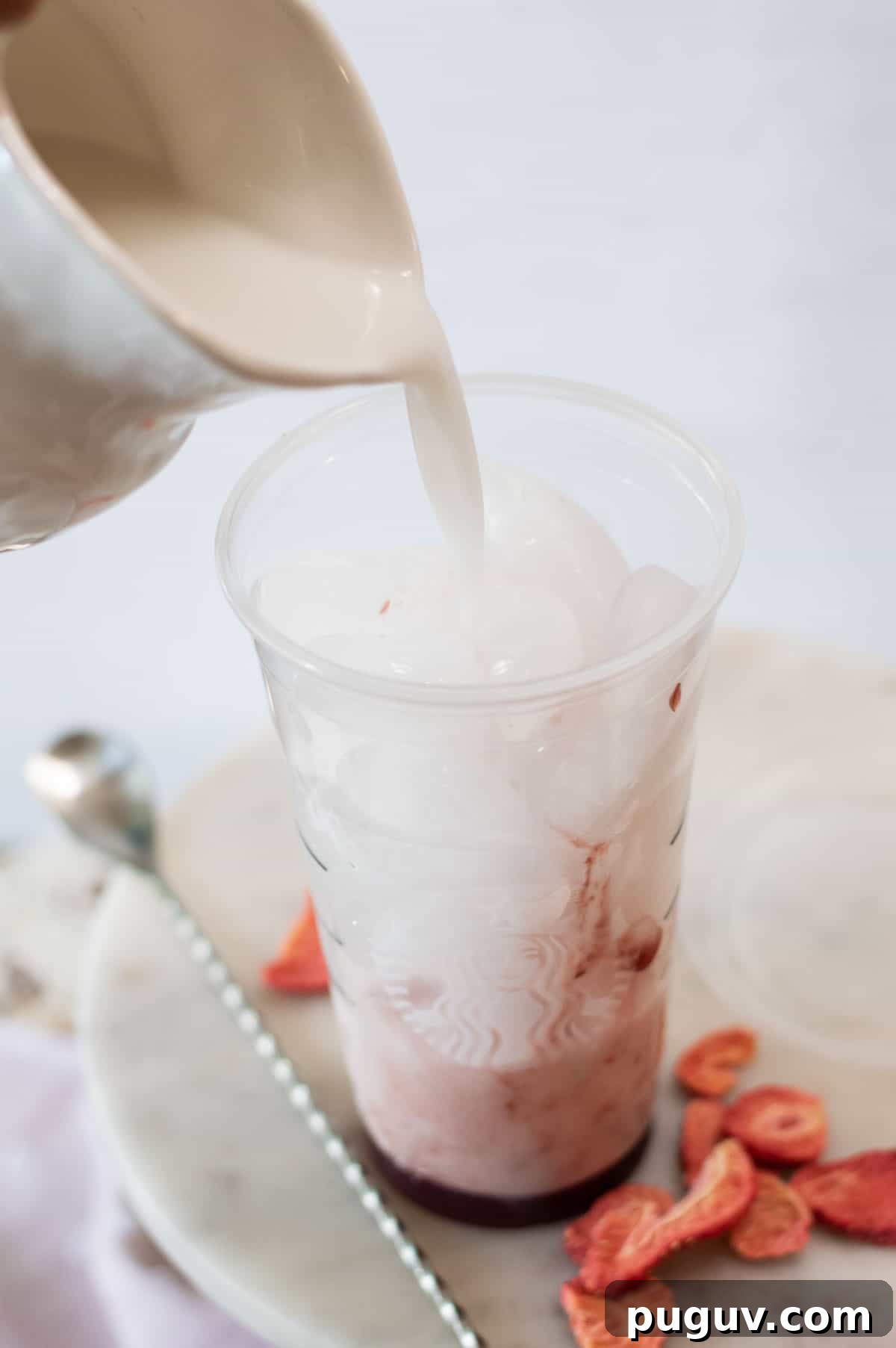 Starbucks Pink Drink Copycat Recipe: How to Make It at Home 5 Starbucks Pink Drink Copycat with coconut milk being poured