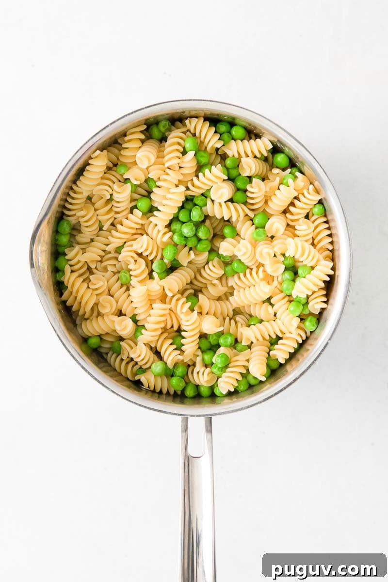 Creamy Pea Pasta with Garlic and Parmesan 7 rotini and green peas in a stock pot