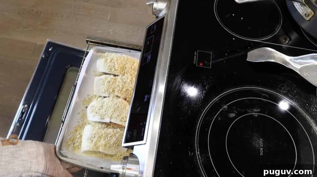 Placing the baking tray with the assembled chicken cutlets in the oven