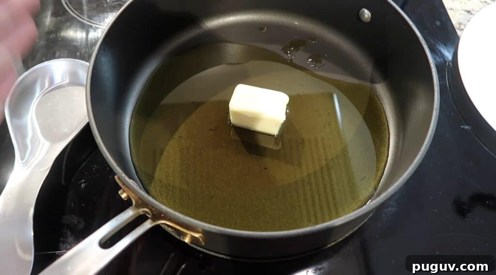 Sauté pan on stove with olive oil and butter