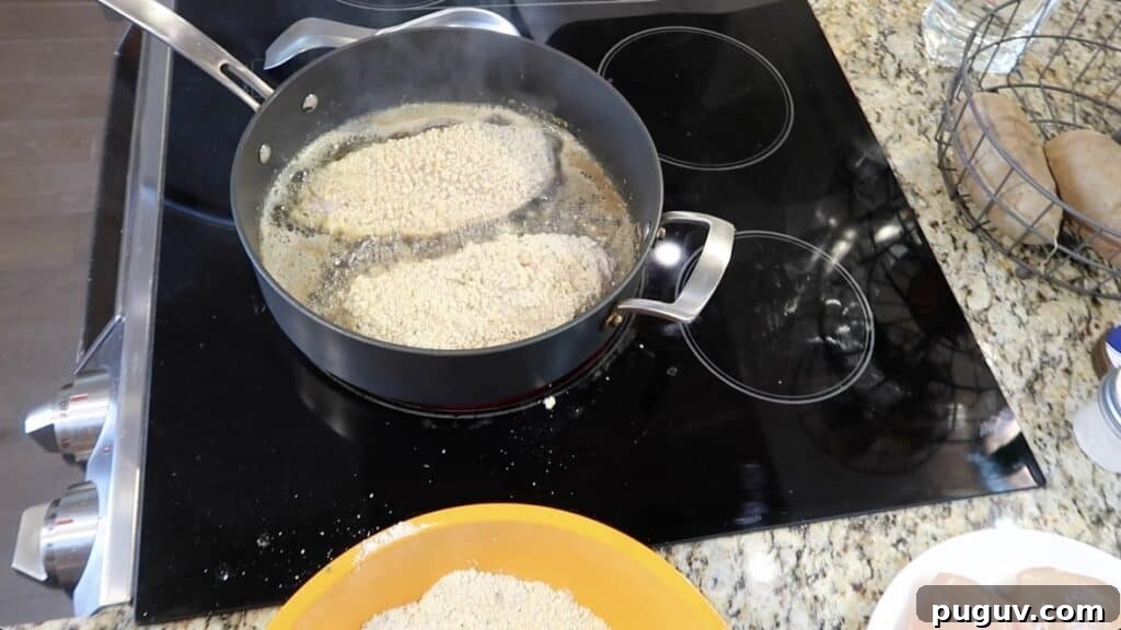 Pan is heated and the breaded cutlets are being pan-fried.