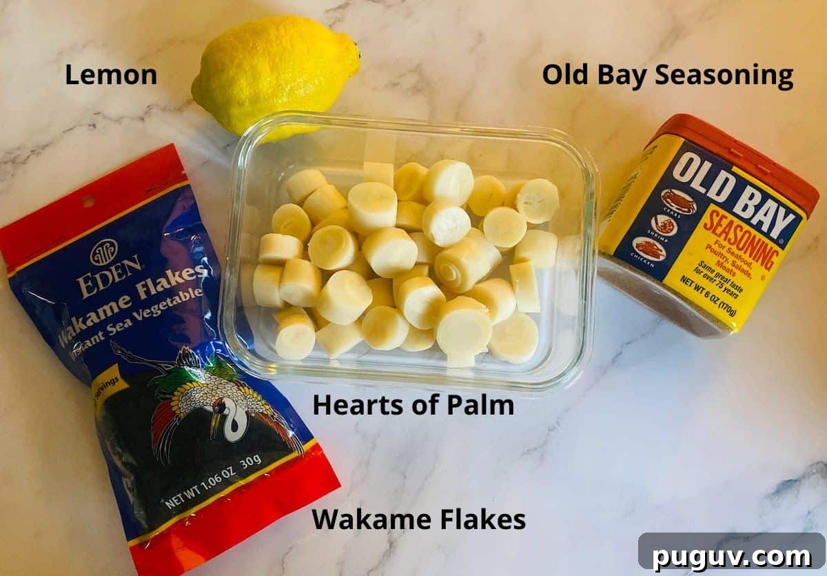 Crispy Vegan Scallops Recipe with Garlic Lemon Butter Sauce 3 Vegan scallops ingredients: hearts of palm cut in a container, lemon, Old Bay Seasoning, and Wakame flakes.