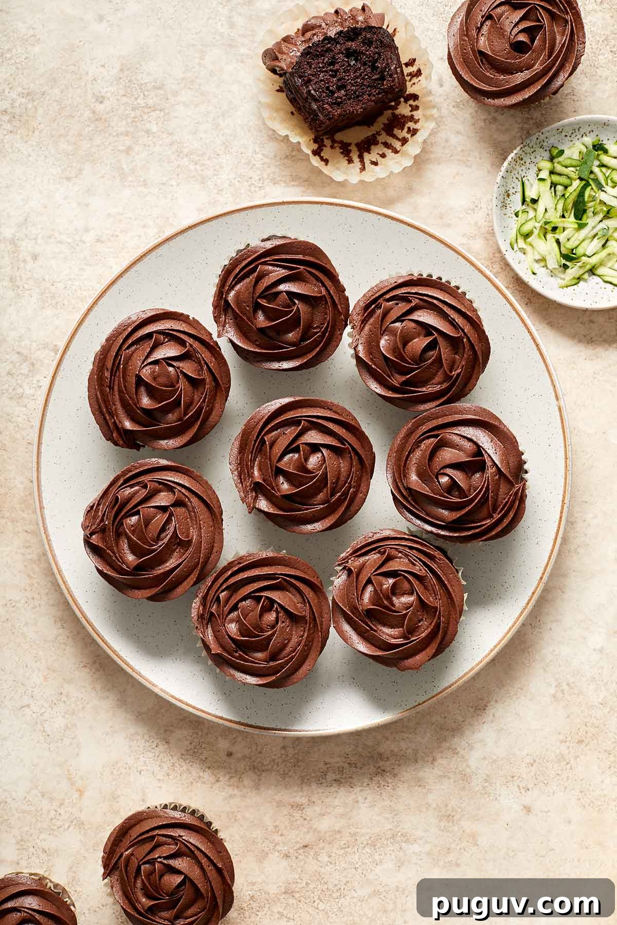 Moist Chocolate Zucchini Cupcakes with Fudgy Cocoa Glaze 8 Overhead view of zucchini cupcakes on a plate and topped with chocolate frosting.