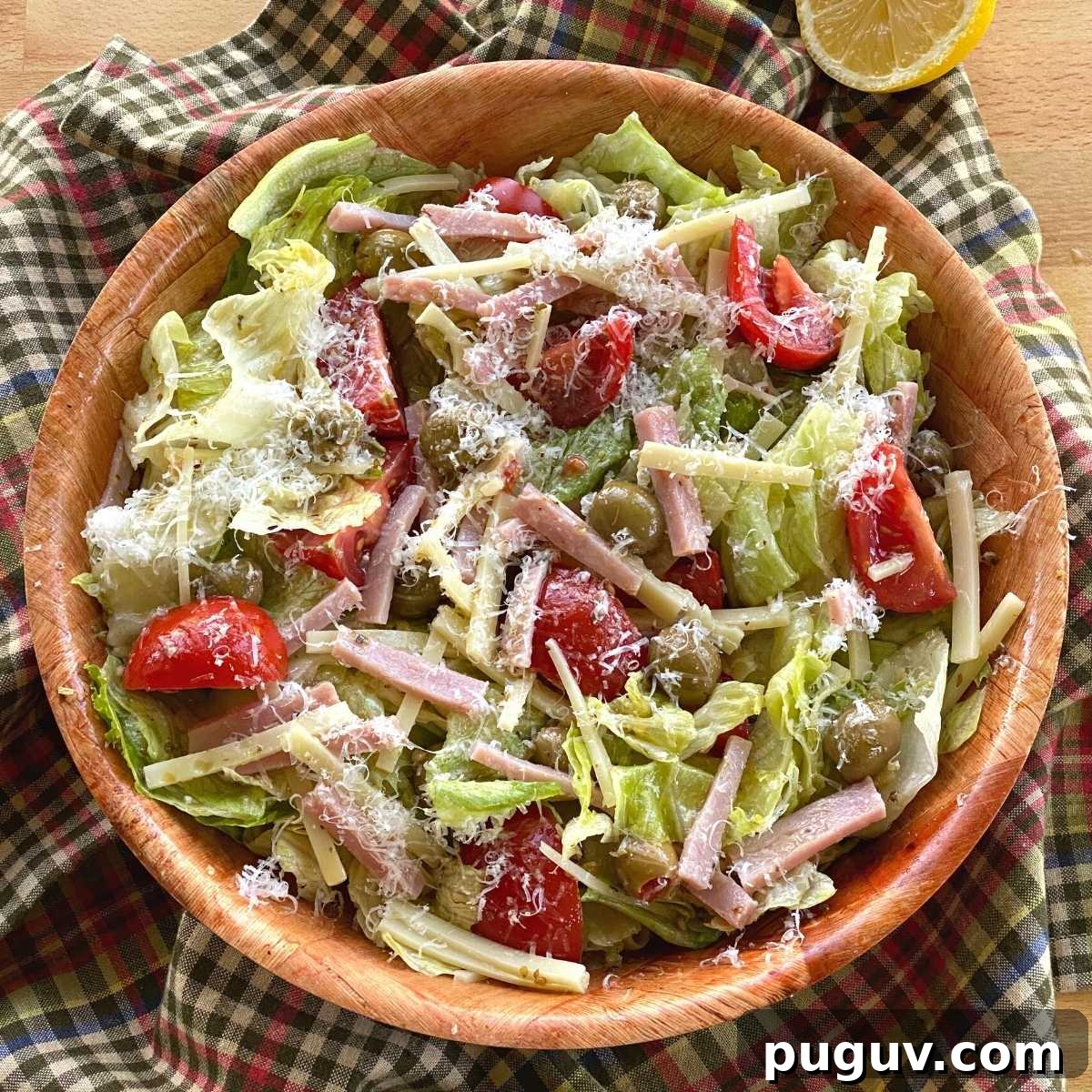 Columbia 1905 Salad with ham, cheese, green olives, and tomatoes and garlic vinaigrette dressing in a bowl.
