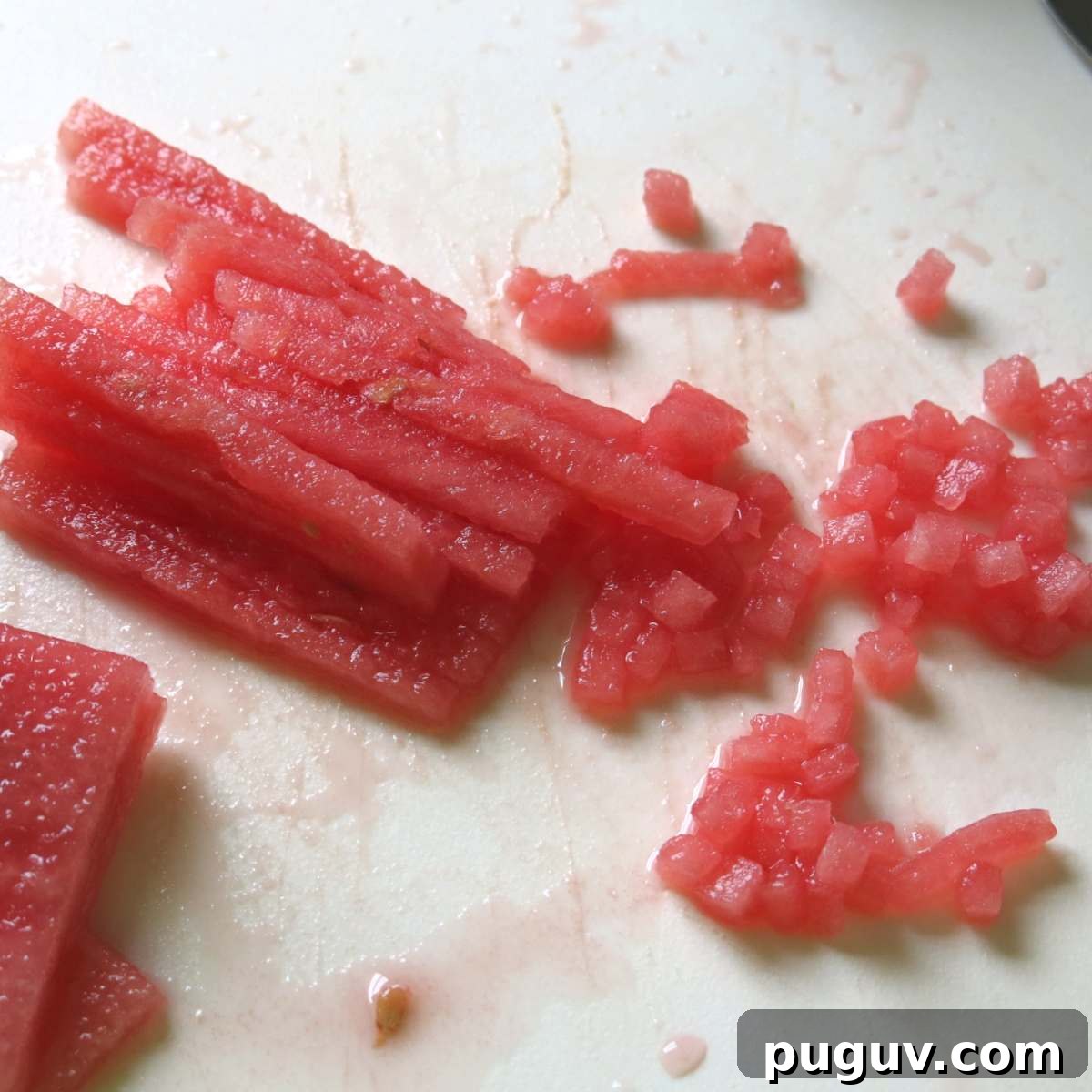 Long skinny rectangular pieces of watermelon partially diced.