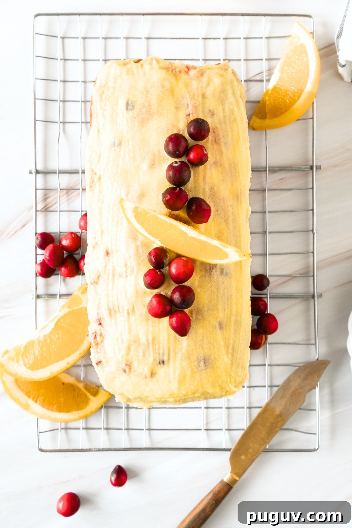 Gluten-Free Cranberry Loaf (Dairy-Free) Glazed orange cranberry bread on wire rack.