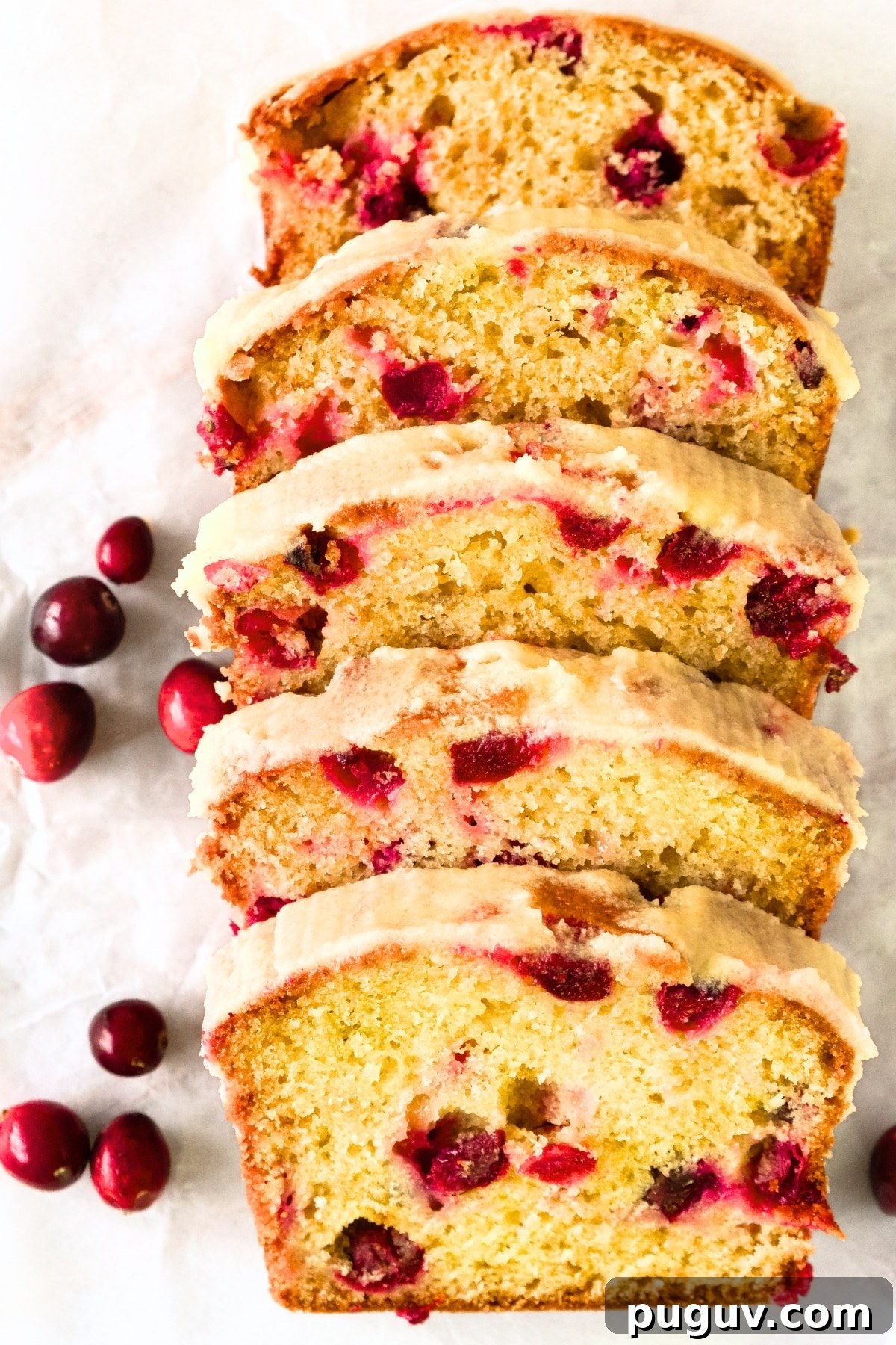 Cranberry Orange Bread (Gluten-Free, Dairy-Free) Sliced cranberry orange bread on parchment paper.