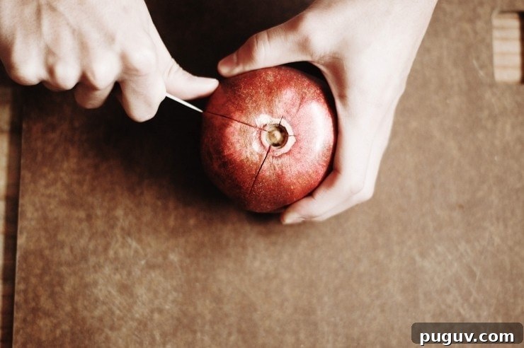 Cutting a pomegranate fruit into sections with a paring knife