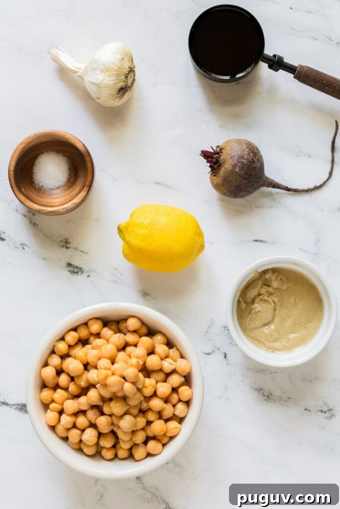 Creamy Beet Hummus Recipe: Vibrant Homemade Dip 3 Ingredients needed to make beet hummus measured in containers and laying on the a marble table.