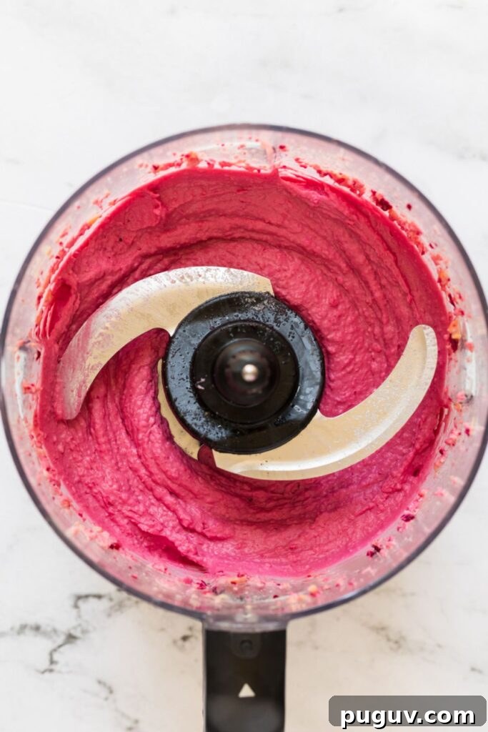 Creamy Beet Hummus Recipe: Vibrant Homemade Dip 6 Beet hummus in a food processor after being mixed.