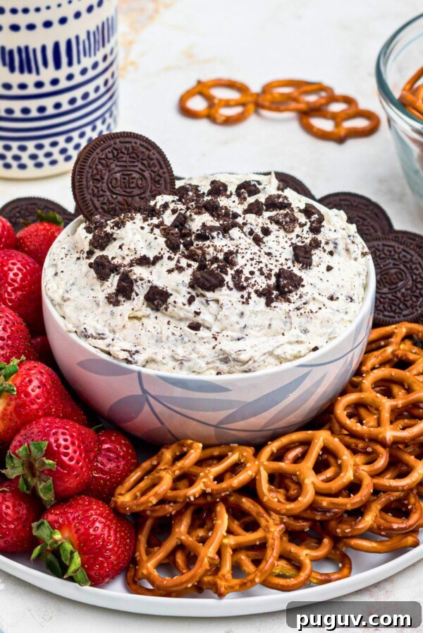 Creamy Beet Hummus Recipe: Vibrant Homemade Dip 10 Strawberries, pretzels, and chocolate cookies, on a round white plate, around a cookies and cream Oreo dip, on a marble table.