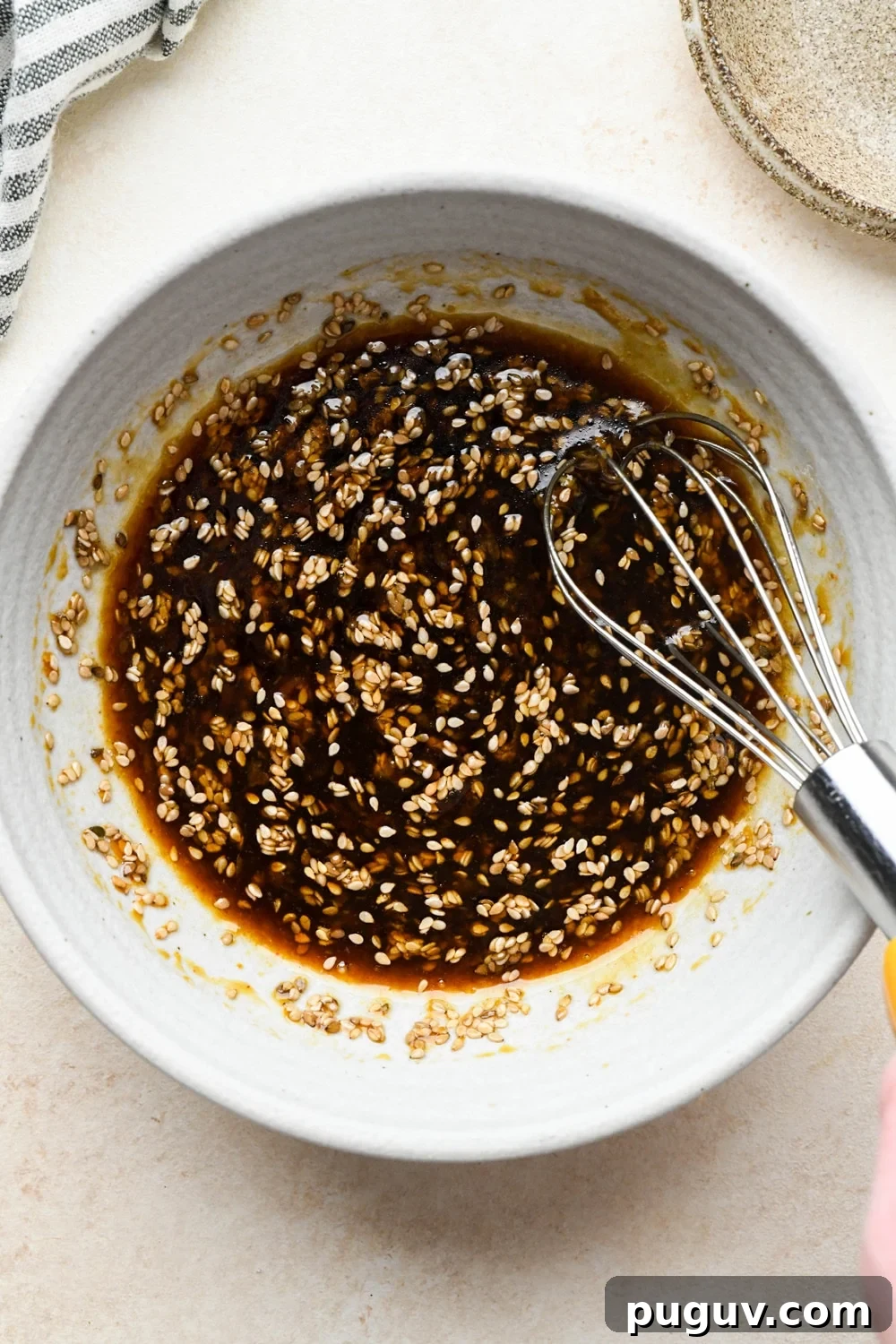 30-Minute Garlic-Ginger Glazed Salmon Recipe (Gluten-Free) 10 How to make garlic ginger salmon: Sauce ingredients in a small grey ceramic bowl, after mixing together with a whisk.