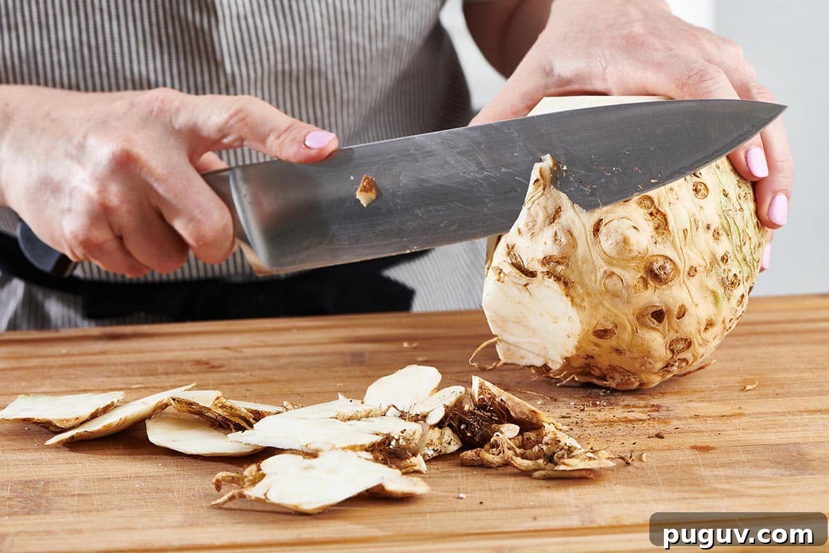 How to Cook Celeriac: Simple Techniques and Delicious Recipes 4 Woman using a large knife to cut the skin off of a celeriac.