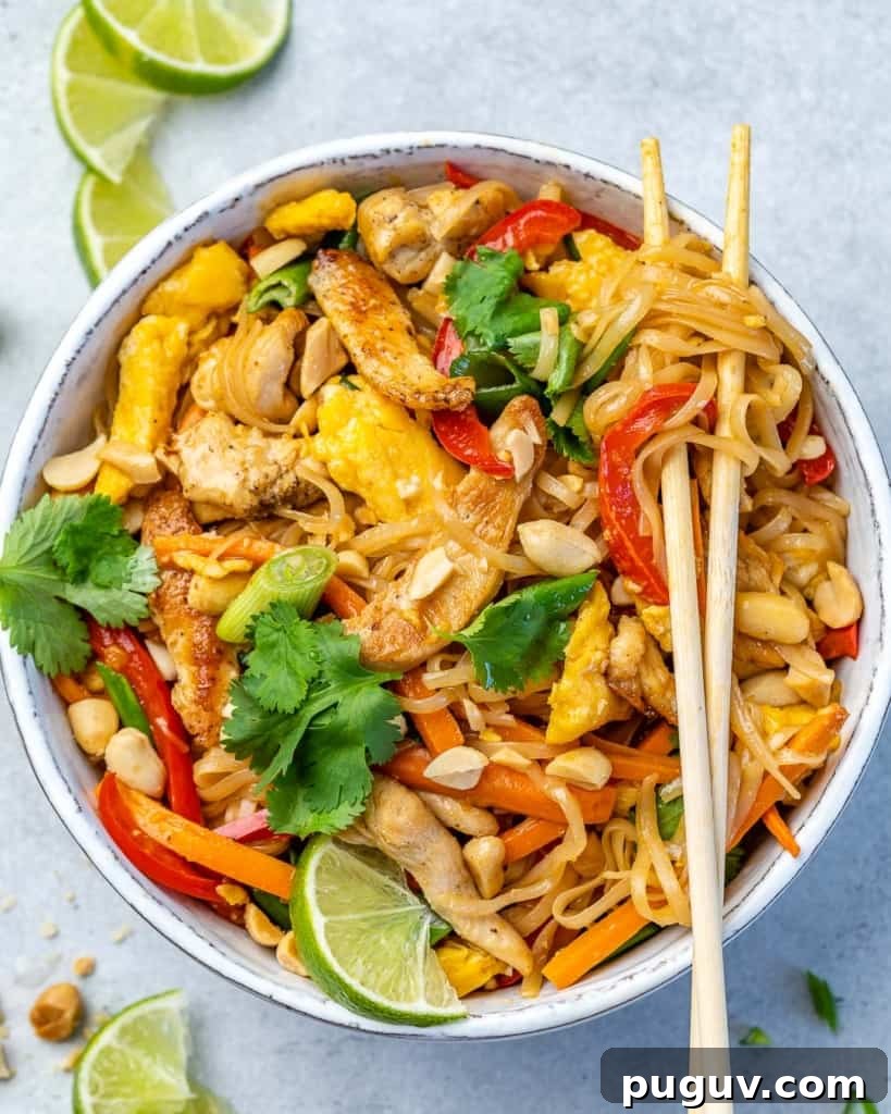 A bowl of chicken pad thai with a pair of chopsticks on top.