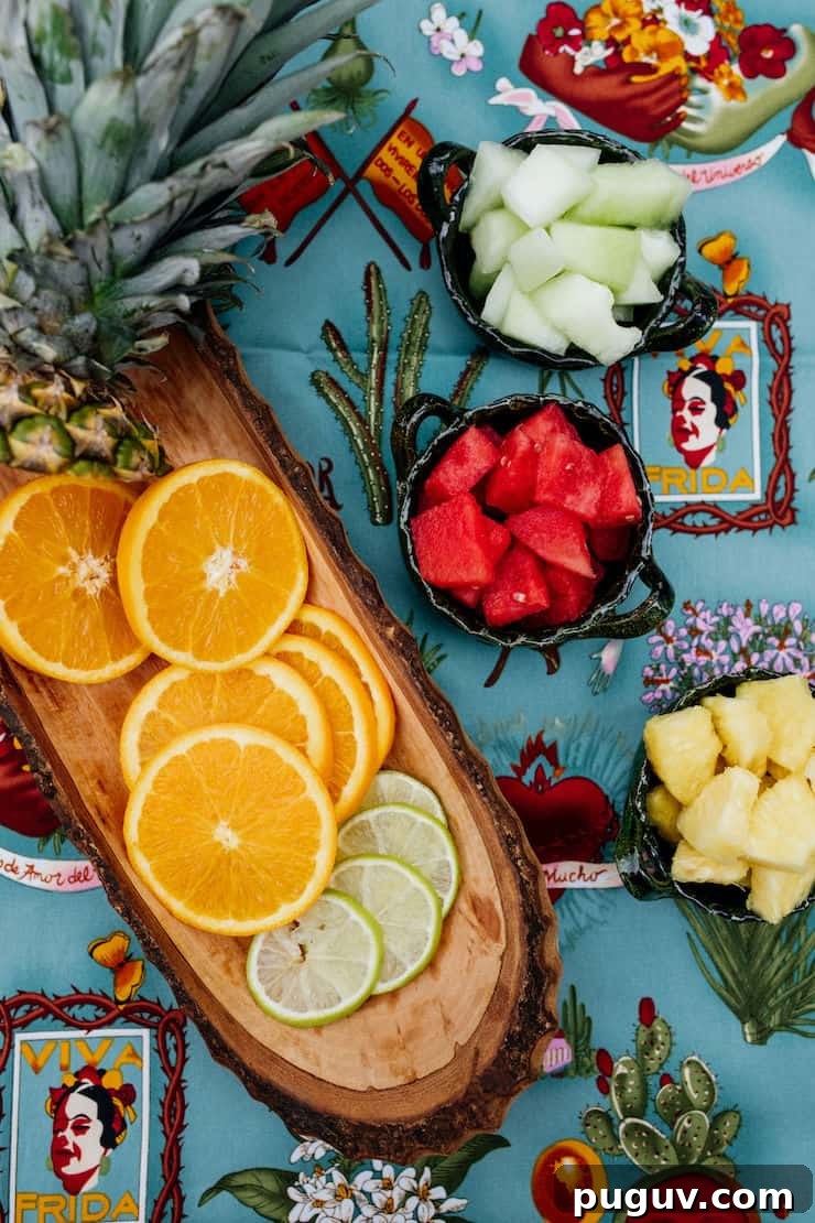 Frida Kahlo-Inspired Sangria Recipe for Parties 4 slices of limes and lemons in a wooden bowl and chopped fruit in small bowls