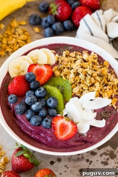An acai bowl topped with fruit, granola and coconut.