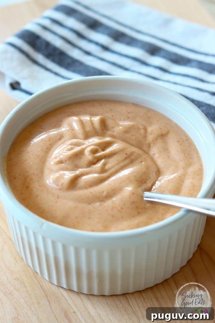 Creamy Yum Yum Sauce Recipe: Simple Homemade Japanese Steakhouse Sauce 2 A white bowl of light orange yum yum sauce ready for serving