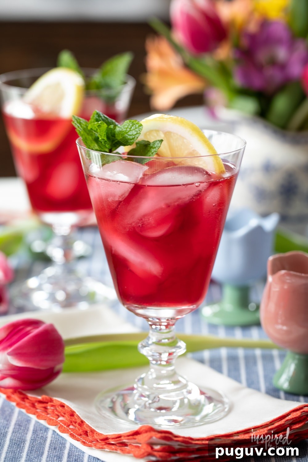 Pink Tulip Cocktail Recipe: Floral Vodka Drink Guide 2 tulip cocktail in footed glass with lemon and mint.