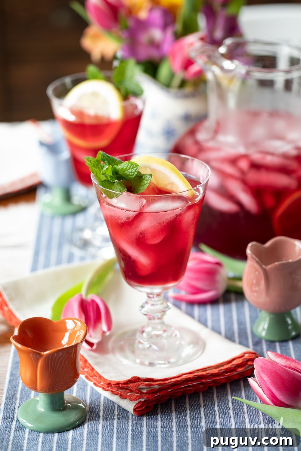 Pink Tulip Cocktail Recipe: Floral Vodka Drink Guide 9 table with glasses filled with tulip cocktails and more served in a pitcher.
