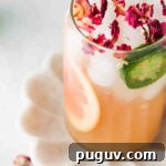 Grapefruit mocktail in a glass with jalapeño slice and grapefruit slice.