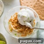 Small custard dish with an individual portion of no bake key lime pie served "upside down," with graham cracker crumbs on top.