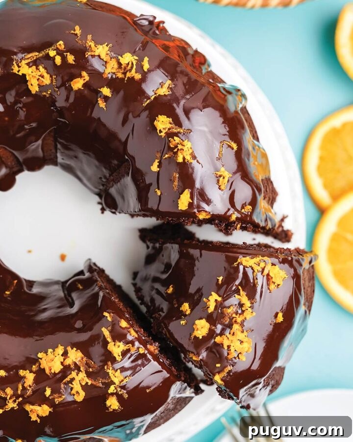Chocolate orange bundt cake on the table with a piece cut and being served.